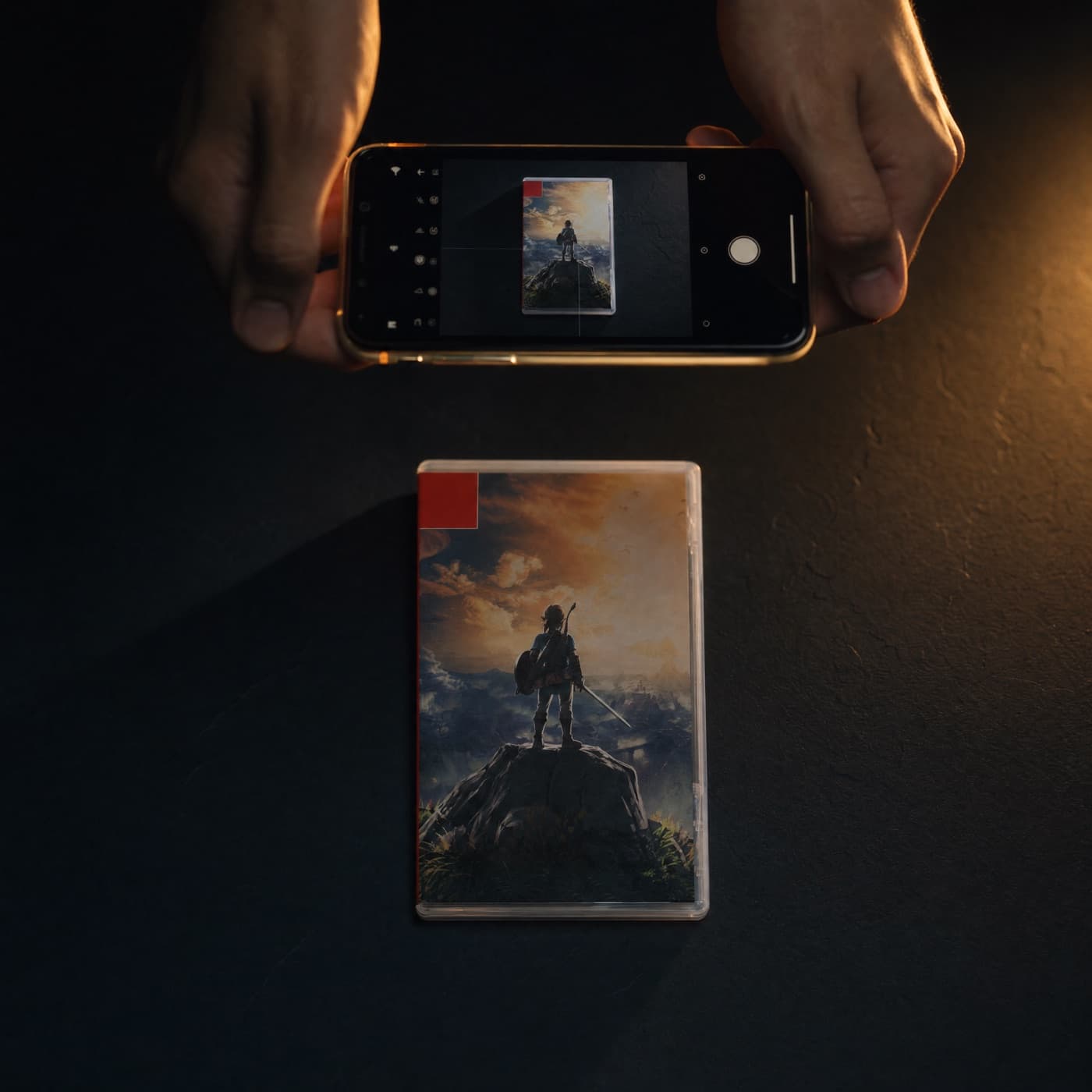 Mains tenant un smartphone pour photographier un jeu Nintendo Switch